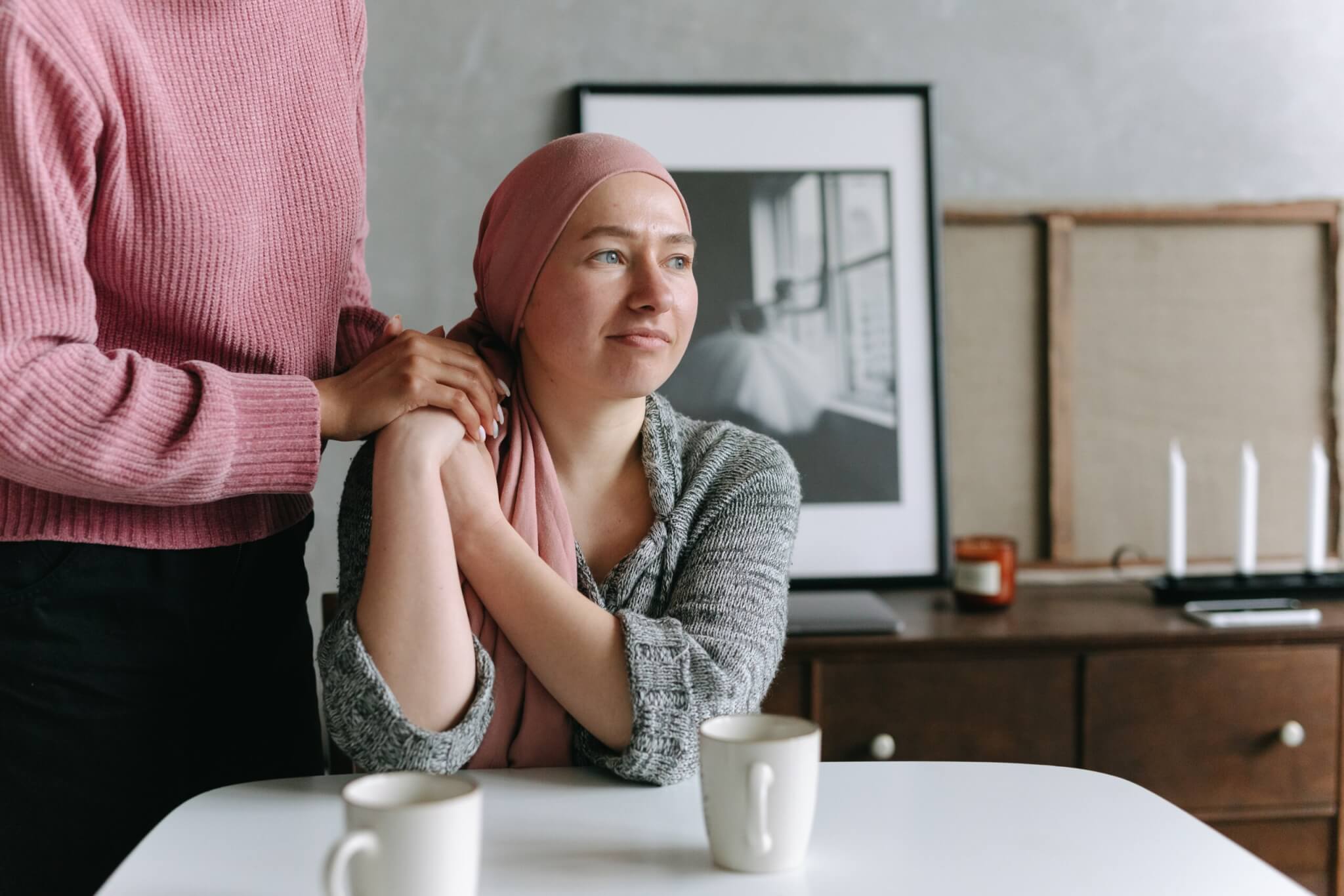 cancer patient with head scarf at table with friend