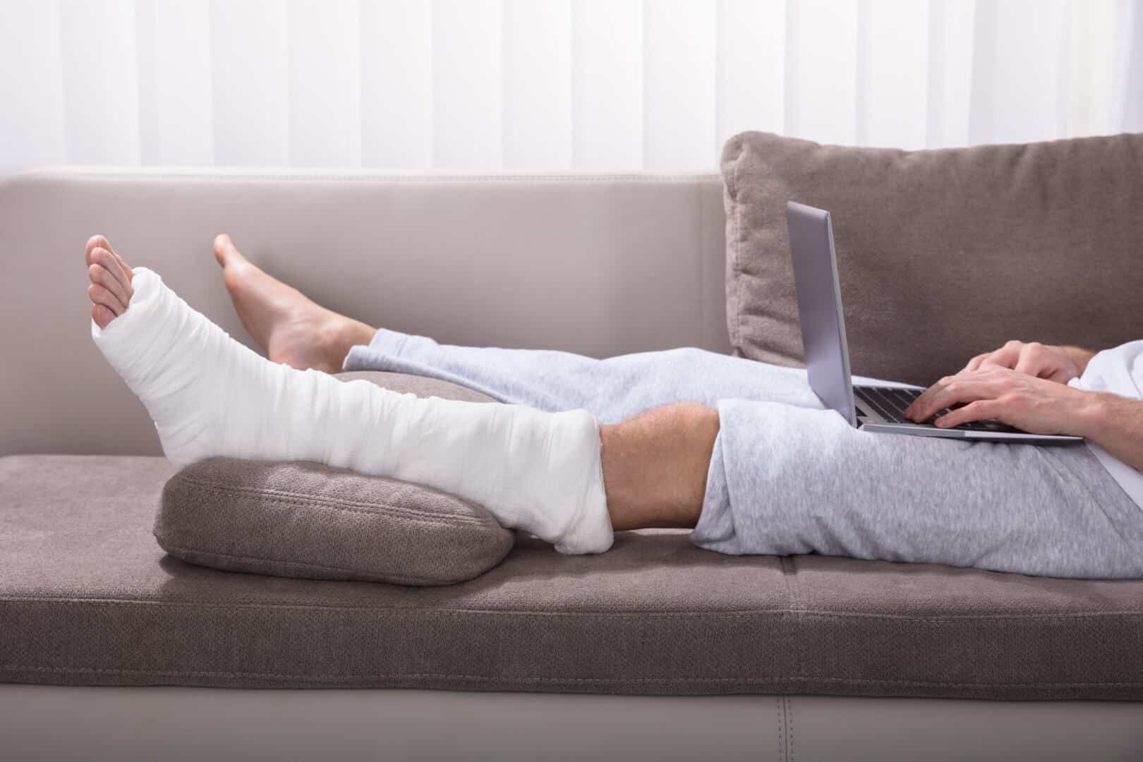 Man with leg cast lying on sofa