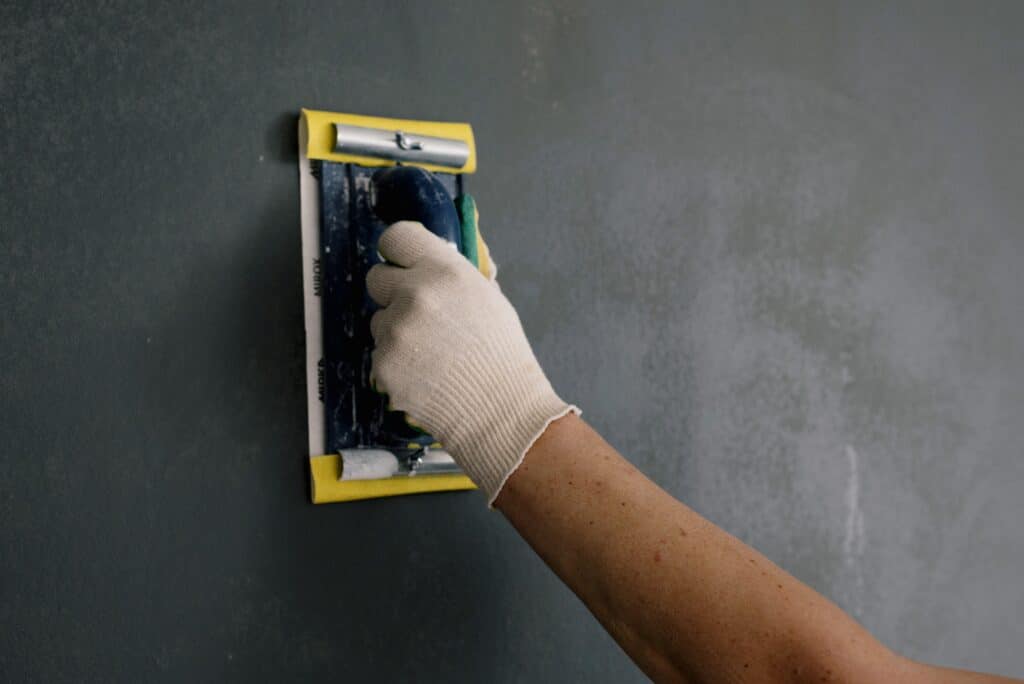 contractor's hand applying texture to a wall