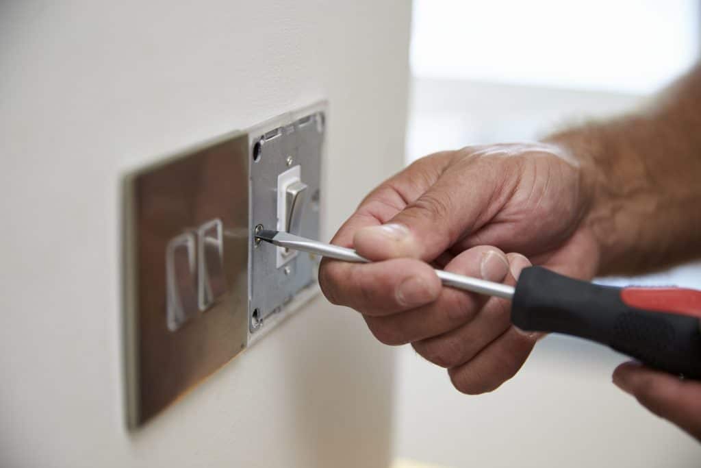 An electrician installing a light switch