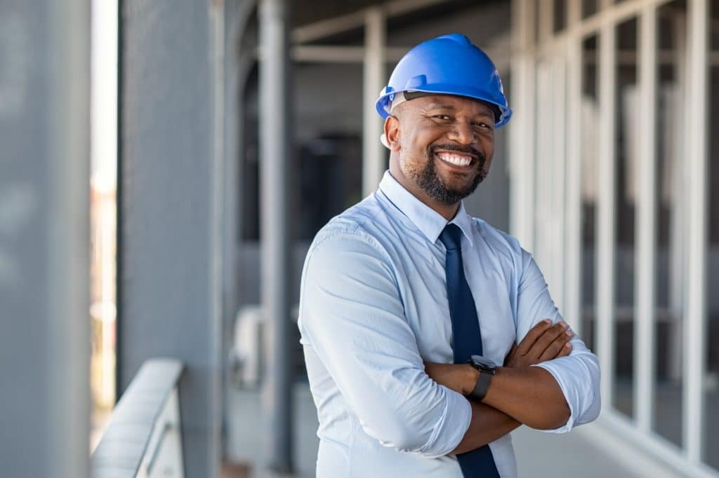 smiling man wearing a blue hard hat on jobsite