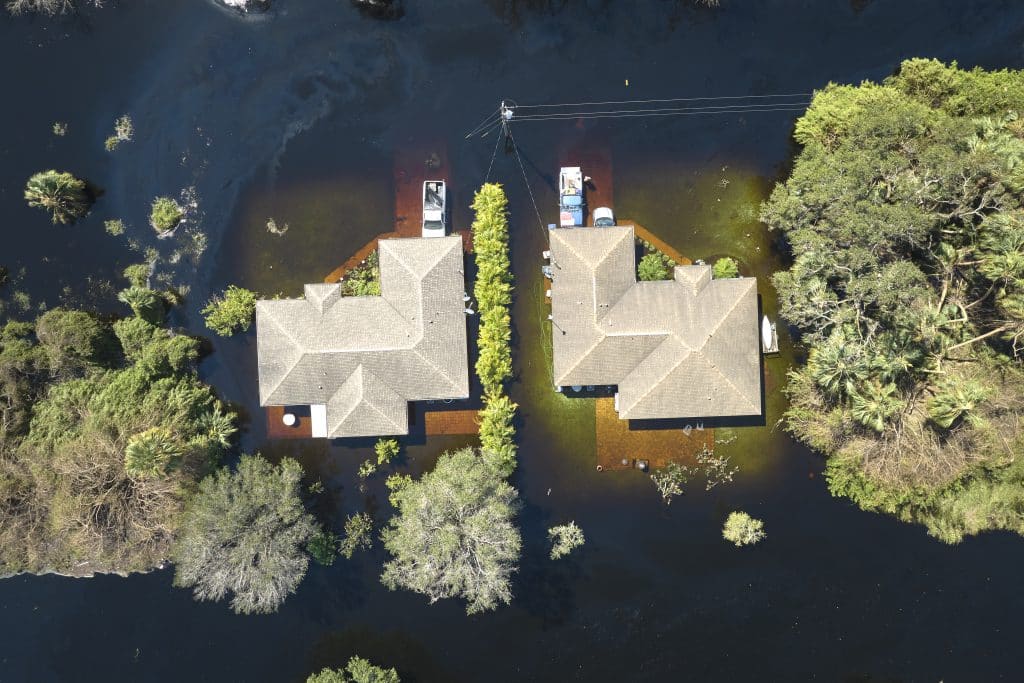 aerial view of two homes flooded after Hurricane Ian