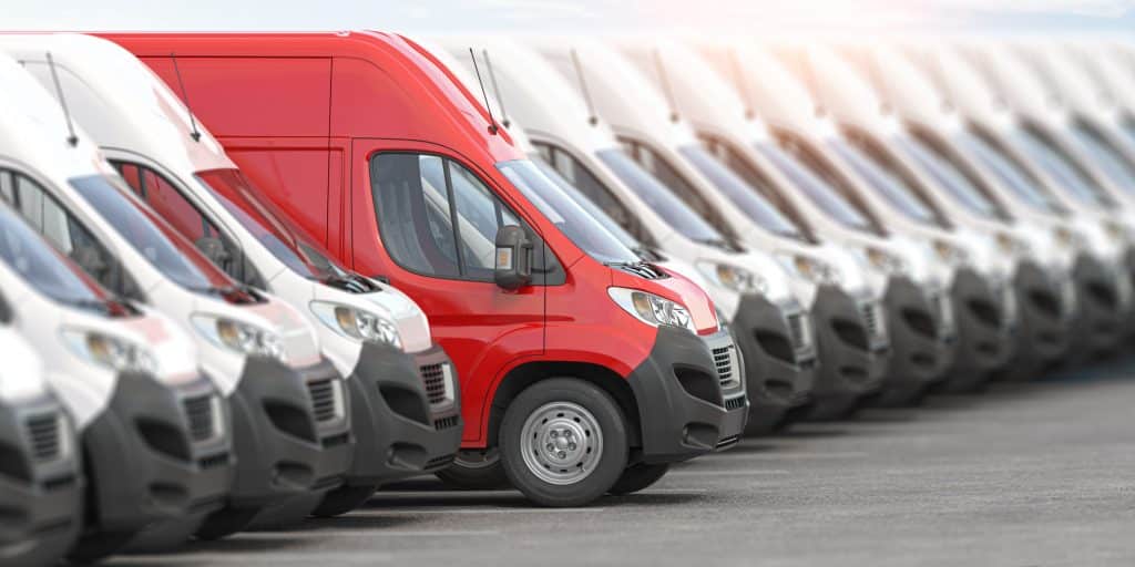 Red delivery van in a row of white vans