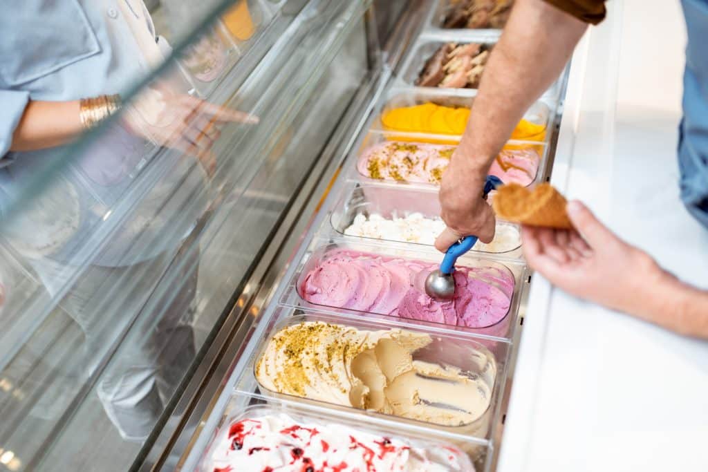 cropped image of person scooping ice cream at ice cream shop