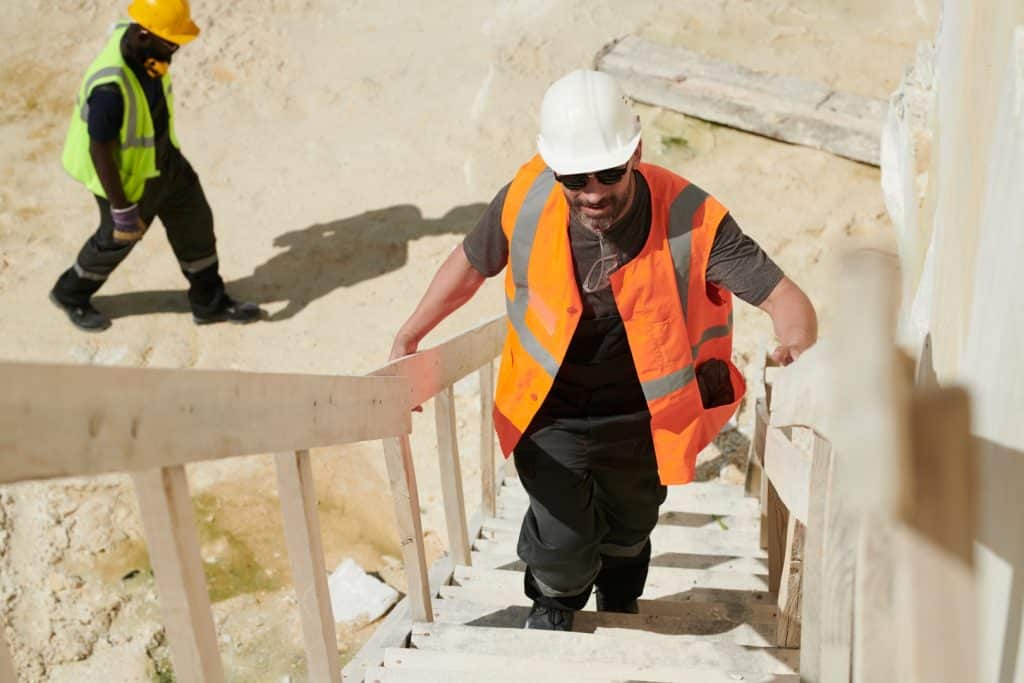 Contractor walking up stairs of new build